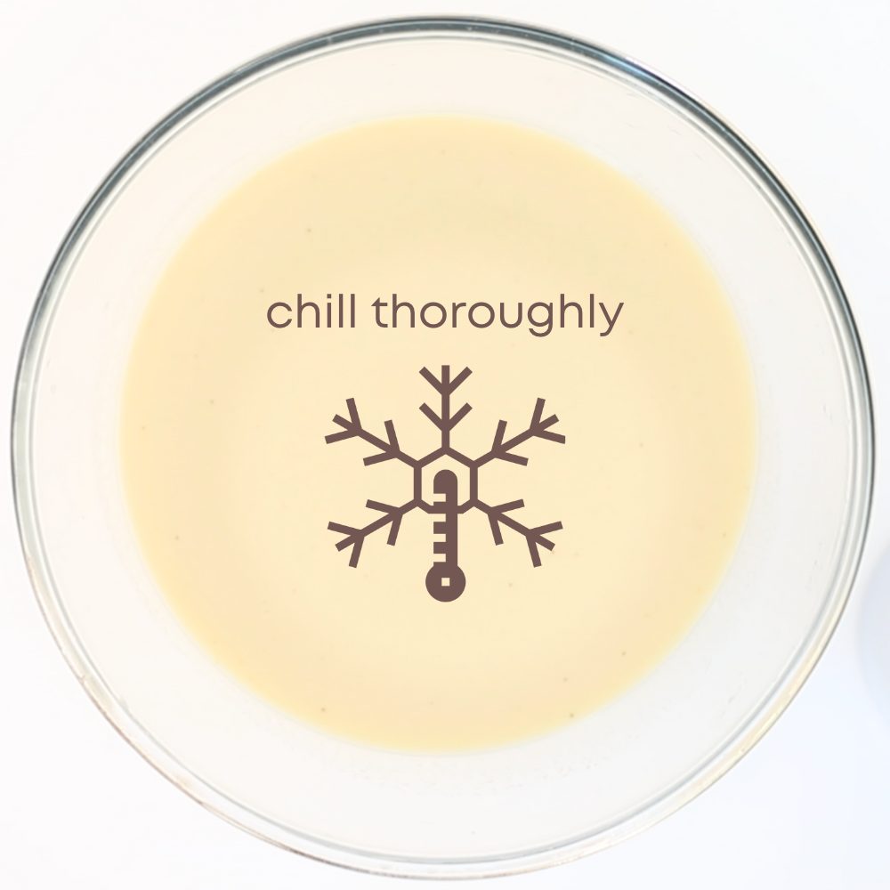 Photo of glass bowl with coffee flavoured ice cream mixture, with a snowflake graphic in the middle and the words "chill thoroughly". The purpose of the image is to show that ice cream mixture must be chilled before using it.